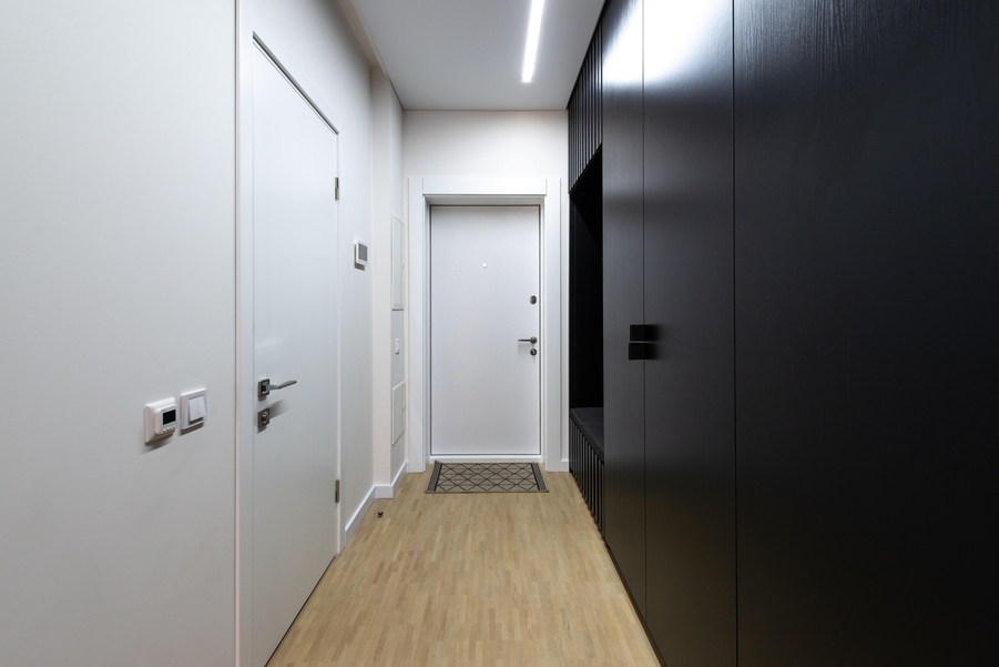 a small corridor with two white doors