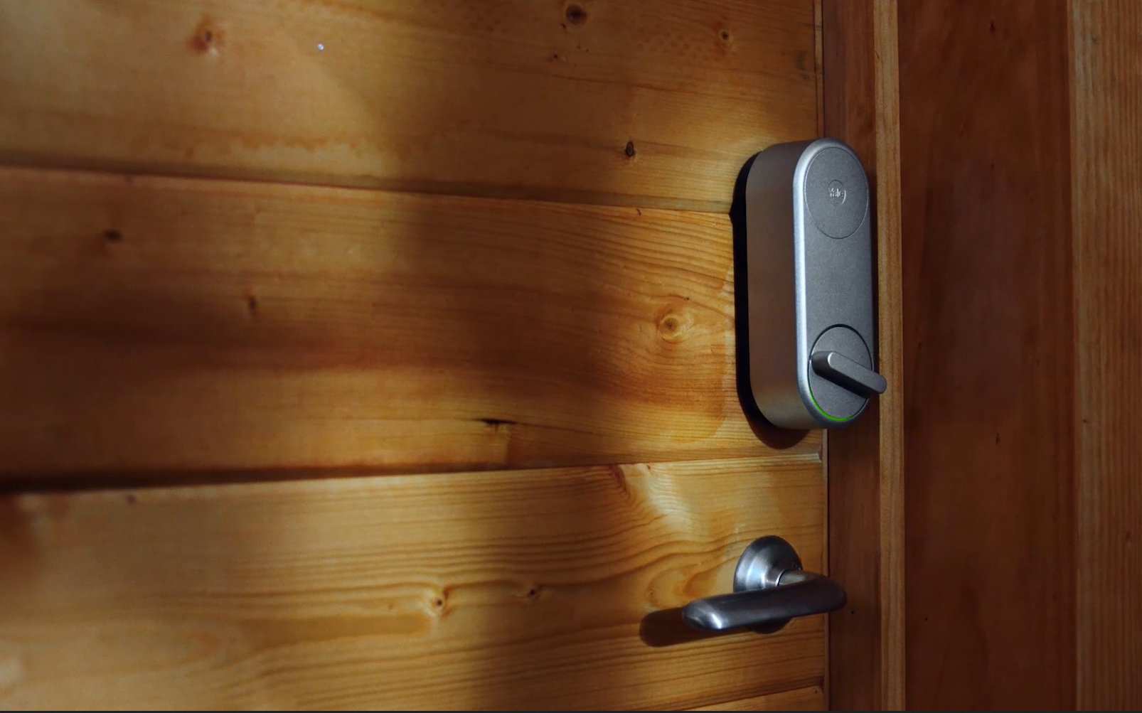 A close up of a wooden door with a motorized lock.