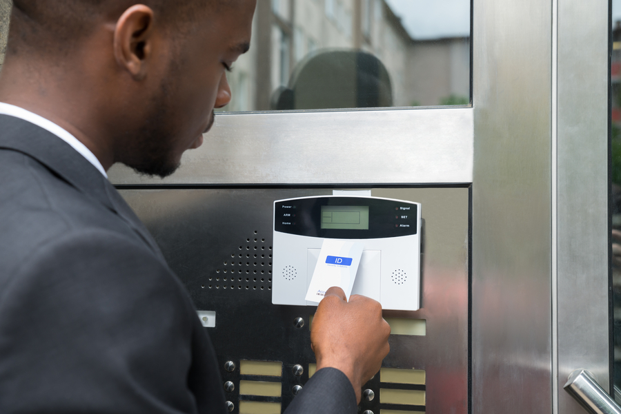 Man using a key card for a touchless access control door system.