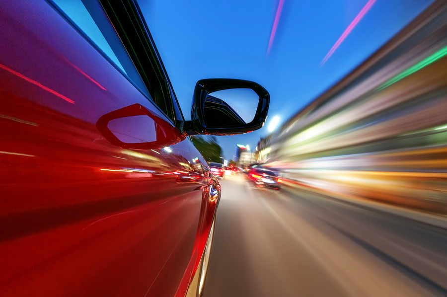 Image is of the side of a bright red new car.