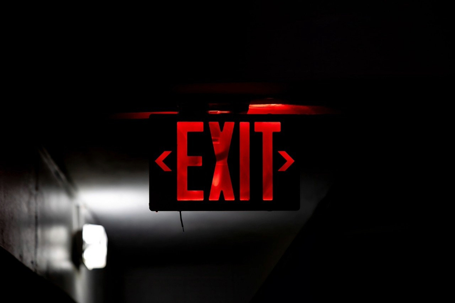 Bright red exit sign glowing in dark.