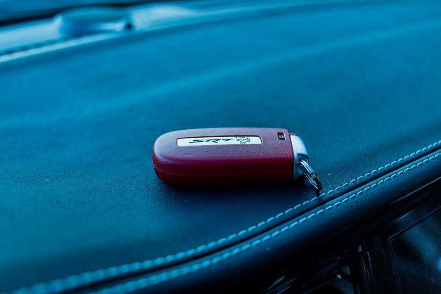 A red key fob on a vehicle's dashboard.