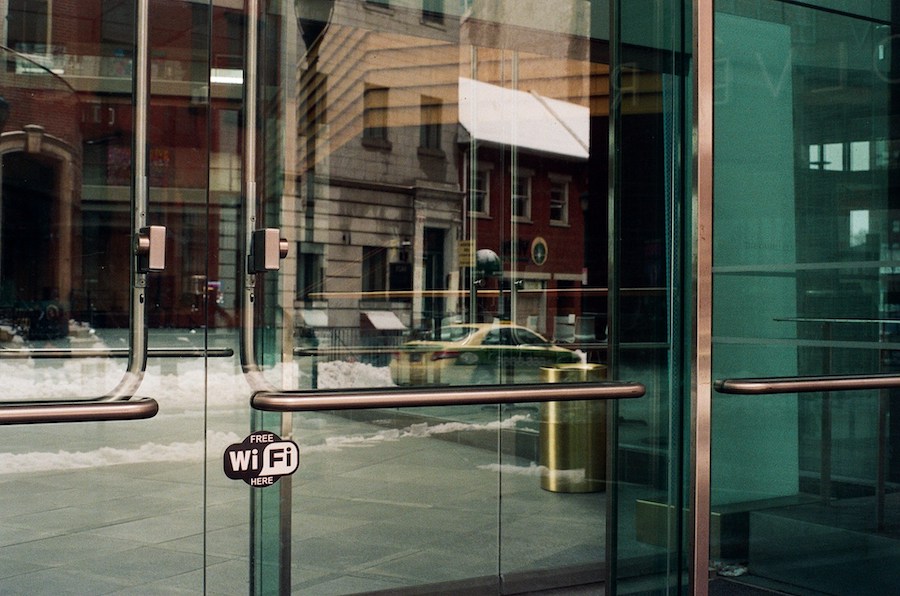 A close-up view of a set of locking glass entry doors to a building.