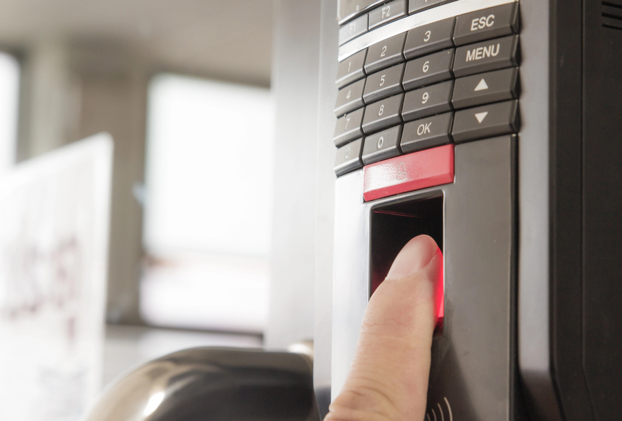 A person’s finger using a biometric access control device.