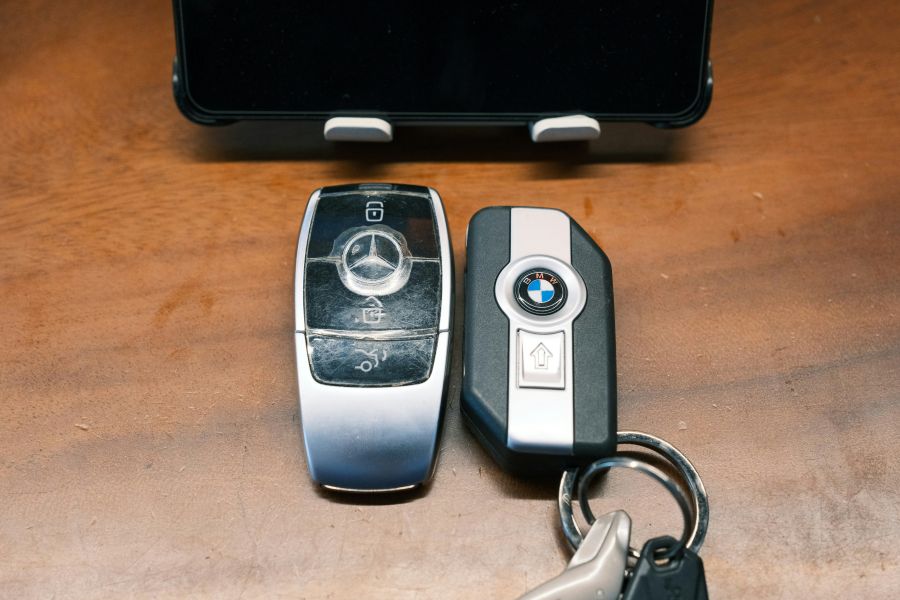 A Mercedes and BMW car key fobs on a table.