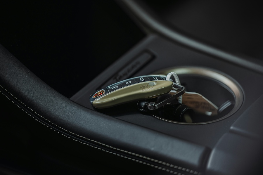 Sleek car key fob resting inside a luxury vehicle center console cup holder.